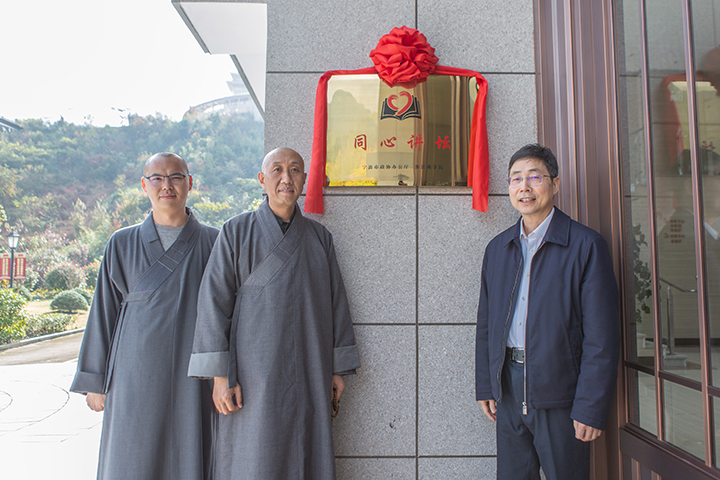 宁波市政协主席徐宇宁和院长怡藏大和尚在“同心讲坛”铜牌前合影